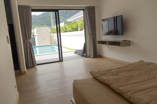 een slaapkamer met een bed en een tv en een zwembad bij casa aviv villa in Nathon Bay
