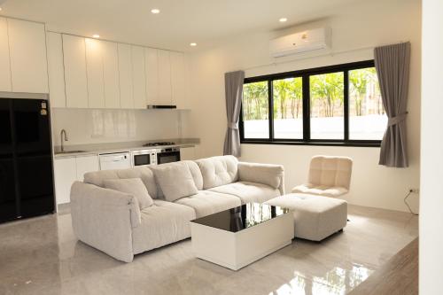 een witte woonkamer met een bank en een stoel bij casa aviv villa in Nathon Bay