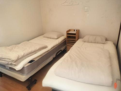 two twin beds in a room with a shelf at Ballarat Clunes in Mino