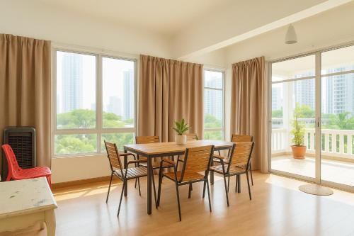Un comedor con mesa y sillas y ventanas. en Near Gurney 3-Storey Event Hse by Felice Homestay, en Tanjong Tokong