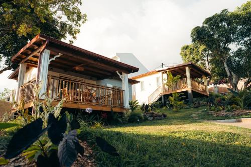 two cottages with wooden decks in a yard at Les Ti Kaz d'Auguste in Les Avirons