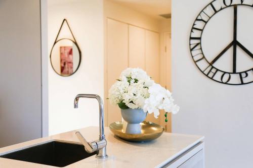 a vase of flowers on a counter next to a sink at Southbank exceptional View with huge balcony High Lvl Suite style APT in Brisbane