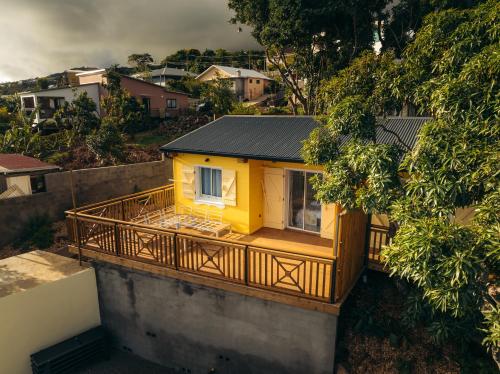 a small yellow house with a balcony on a building at Les Ti Kaz d'Auguste in Les Avirons