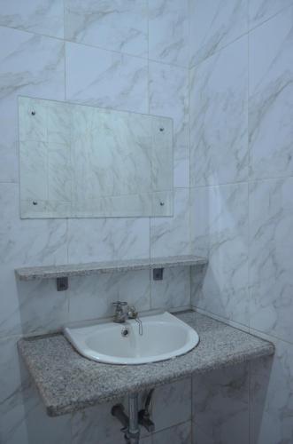 a white sink in a bathroom with a mirror at Villa Omah Jamuniro in Ngasinan