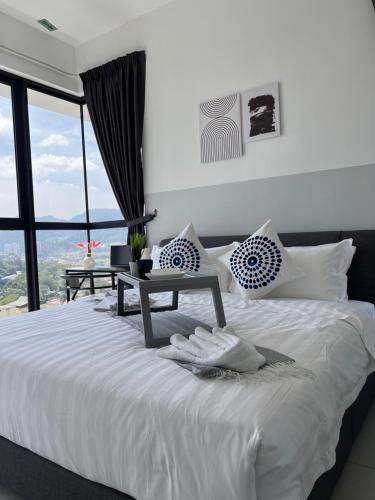 a bedroom with a white bed with a table on it at Georgetown Urban Family & Baby-Friendly Home with Skypool Seaview in Jelutong