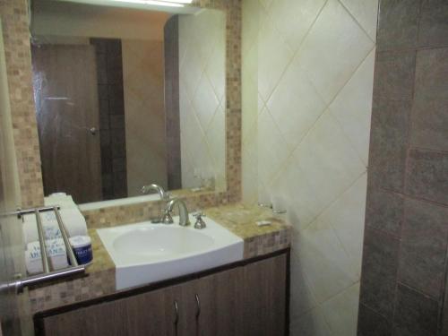 a bathroom with a sink and a mirror at Indiana Beach Apartments in Bamburi