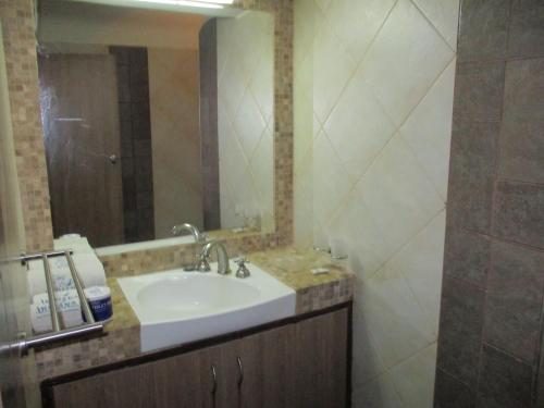 a bathroom with a sink and a mirror at Indiana Beach Apartments in Bamburi