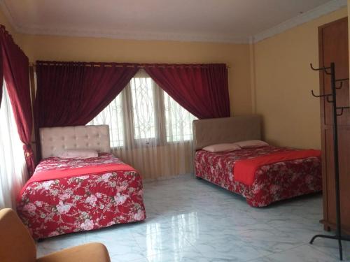two beds sitting in a room with a window at Villa Omah Jamuniro in Ngasinan
