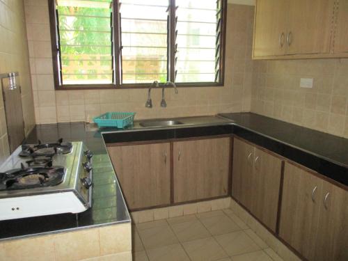 a kitchen with a sink and a stove in it at Indiana Beach Apartments in Bamburi