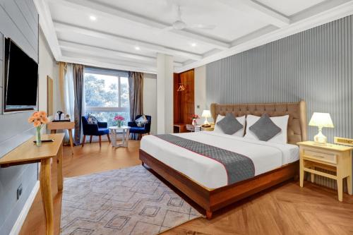 a hotel room with a large bed and a desk at Hotel Aerotech Near Delhi Airport in New Delhi