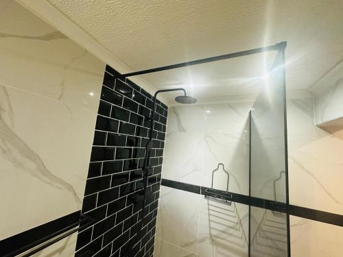 a shower with a glass door in a bathroom at Siyaya’s Guest Palace in Jozini