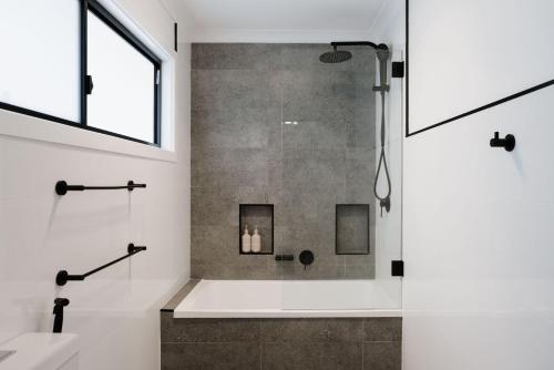 a bathroom with a shower with a glass door at Bayview Beach House - Pet Friendly Holiday Home with a Pool - Holiday Yamba in Yamba