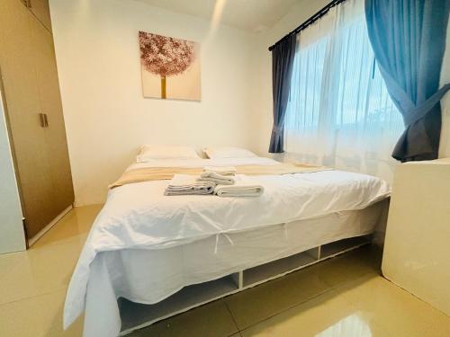 Phuket naka Condon-41无边泳池免费上网免费停车位 في فوكيت تاون: غرفة نوم بها سرير بملاءات بيضاء ونافذة