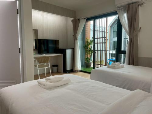 een hotelkamer met twee bedden en een balkon bij Salty Sand Krabi Hotel in Ban Khlong Haeng