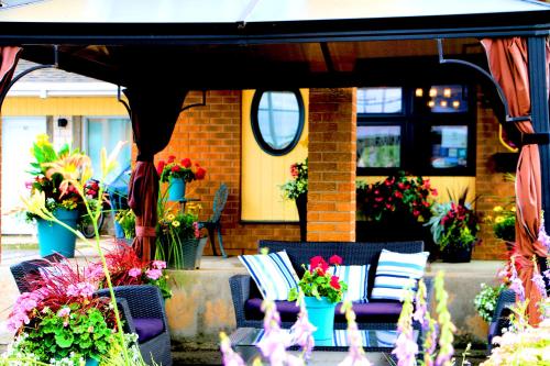 a patio with chairs and potted plants and an umbrella at Motel Centre-Ville in Montmagny