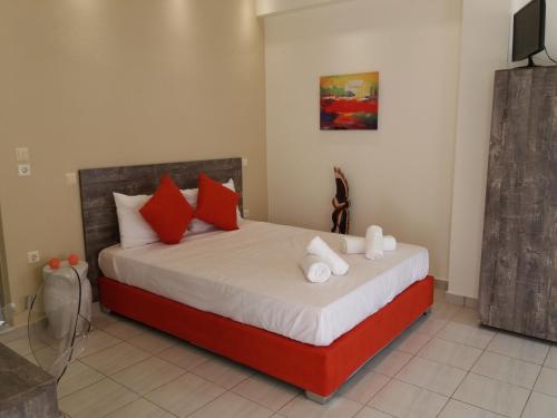 a bedroom with a bed with red and white pillows at Asterolithos in Fira