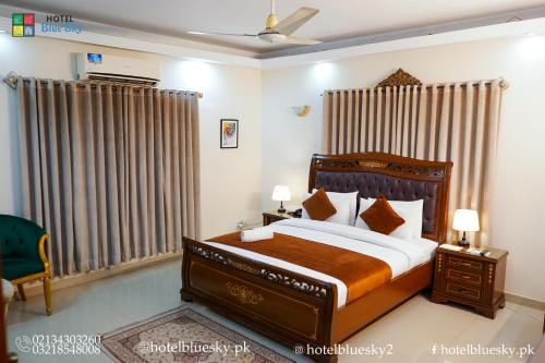una camera da letto con un letto grande con testiera in legno di Blue Sky Hotel Clifton 2 a Karachi