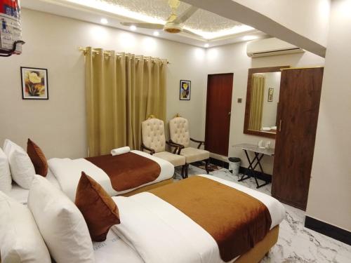 Blue Sky Hotel Clifton 2 في كراتشي: غرفة فندقية بسريرين ومرآة