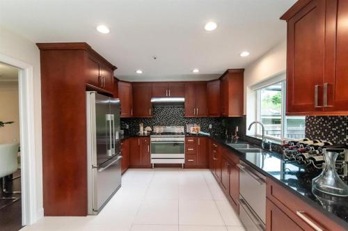 a large kitchen with wooden cabinets and stainless steel appliances at W 20 House in Vancouver