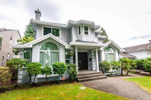 a white house with a green yard at W 20 House in Vancouver