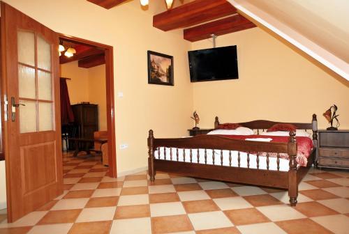 a bedroom with a bed and a television on the wall at Hotel Pelikán in Třeboň