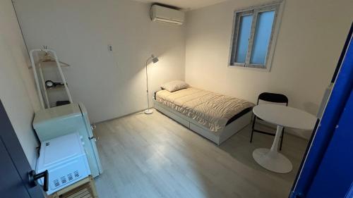 a small bedroom with a bed and a table at SRR Stay in Gwangmyeong