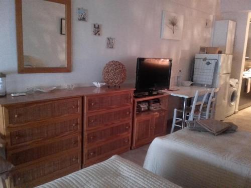 a bedroom with a dresser with a television and a refrigerator at Property Direct Stadem Apartment Second Floor in Larnaca