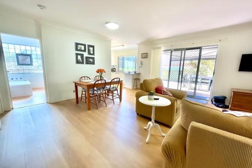 una sala de estar con un sofá y una mesa en Cronulla courtyard unit, 10 mins walk to Beach & Bay, en Cronulla