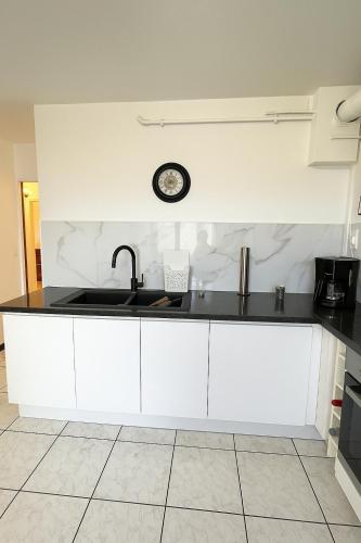 a kitchen with a sink and a clock on the wall at Appartement t3 à Montpellier in Montpellier