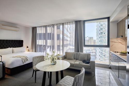a hotel room with a bed and a large window at Meriton Suites Campbell Street, Sydney in Sydney
