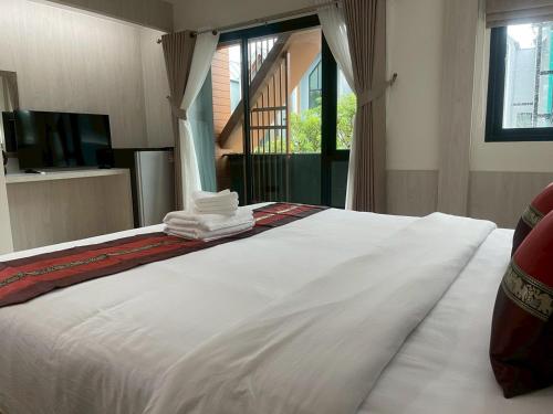 een groot wit bed met handdoeken erop bij Salty Sand Krabi Hotel in Ban Khlong Haeng