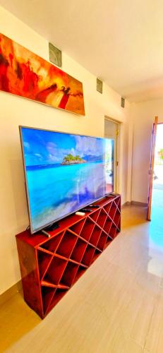 una TV a schermo piatto posizionata sopra un centro di intrattenimento di Edelmon't Beach a Los Órganos
