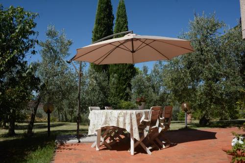 a table and chairs with an umbrella in a park at Da Piero e Paola in Arezzo