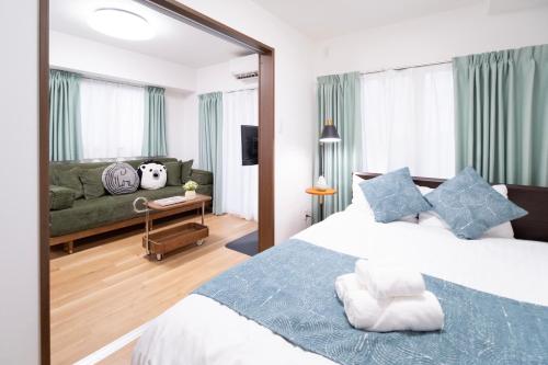 a bedroom with a large bed and a couch at The Peak Tengachaya in Osaka