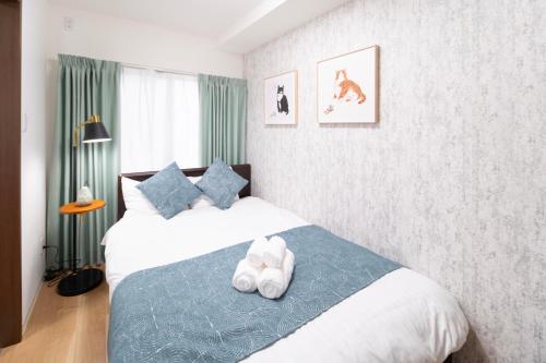 a bedroom with two beds and a blue blanket at The Peak Tengachaya in Osaka