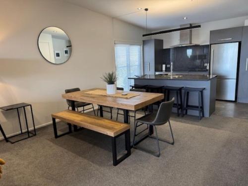 a kitchen and dining room with a table and chairs at Top Floor Mount Central Apartment with Pool & Spa in Mount Maunganui