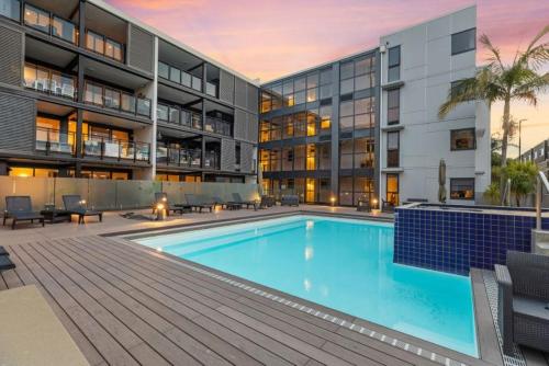 a large swimming pool in front of a building at Top Floor Mount Central Apartment with Pool & Spa in Mount Maunganui