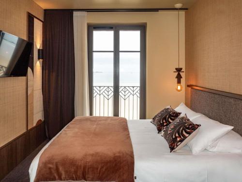 Habitación de hotel con cama y ventana grande en Mercure St Malo Front de Mer, en Saint-Malo