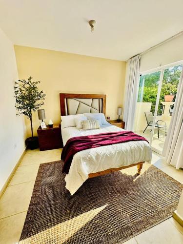 ein Schlafzimmer mit einem großen Bett und einem großen Fenster in der Unterkunft Casa completa en fraccionamiento privado San Jerónimo Coatepec in Coatepec