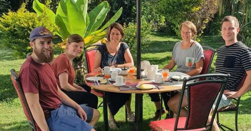 a group of people sitting around a table at Homebase gardens homestay in Nakuru
