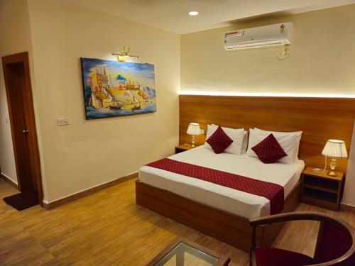 una habitación de hotel con una cama y un cuadro en la pared en The Retreat, en Mirzāpur