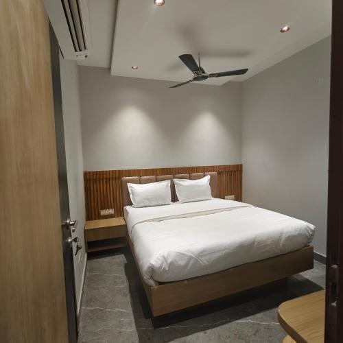 a bedroom with a white bed with a ceiling at Hotel Elev11 in Zirakpur