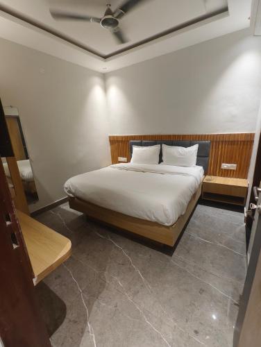 a bedroom with a bed with white sheets and a ceiling at Hotel Elev11 in Zirakpur