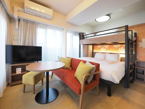 een hotelkamer met een bed, een bank en een tafel bij HIYORI Stay Kyoto Kamogawa in Kyoto