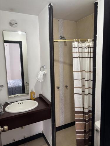 a bathroom with a sink and a shower with a mirror at Comfortable apartment in South Quito in Quito
