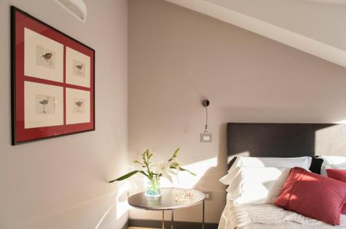 a bedroom with a bed and a table with a vase of flowers at Palazzo del Senatore in Atina