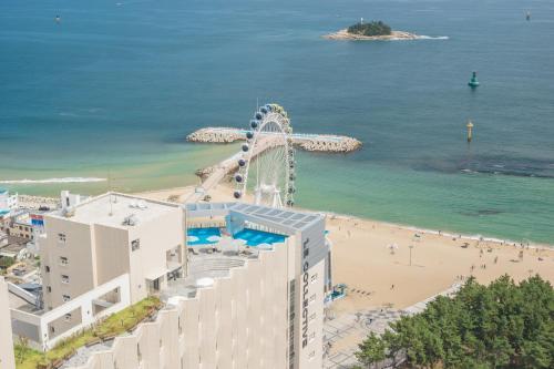 een reuzenrad op een strand naast de oceaan bij Richeville Signature Hotel and Residence in Puwŏl-li