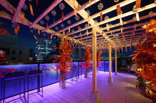 a row of chairs on a rooftop at night at The Lively Osaka Honmachi in Osaka