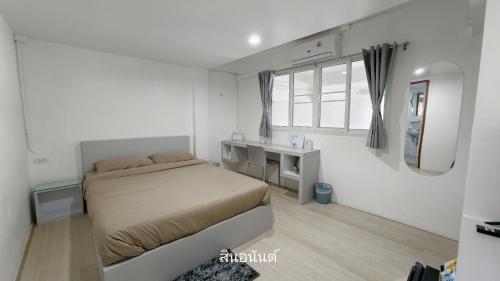 a bedroom with a bed and a desk and a mirror at สินอนันต์ อพาร์ทเม้นต์Sinanan apartment in Ban Bang Saen (1)