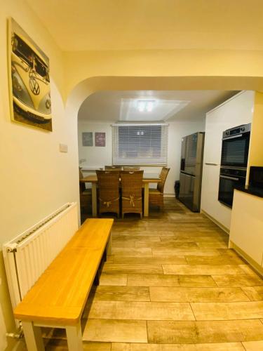a living room with a bench and a table at Relax in this Charming East Cowes House with Garden and BBQ in East Cowes